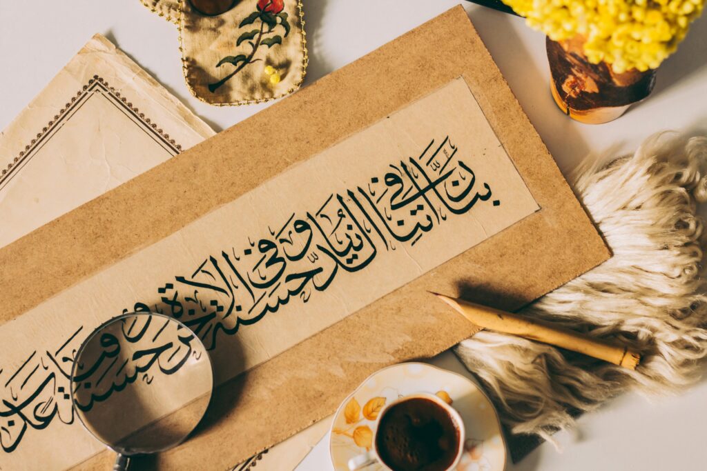 Elegant arrangement featuring Arabic calligraphy and traditional items like a magnifying glass and coffee.